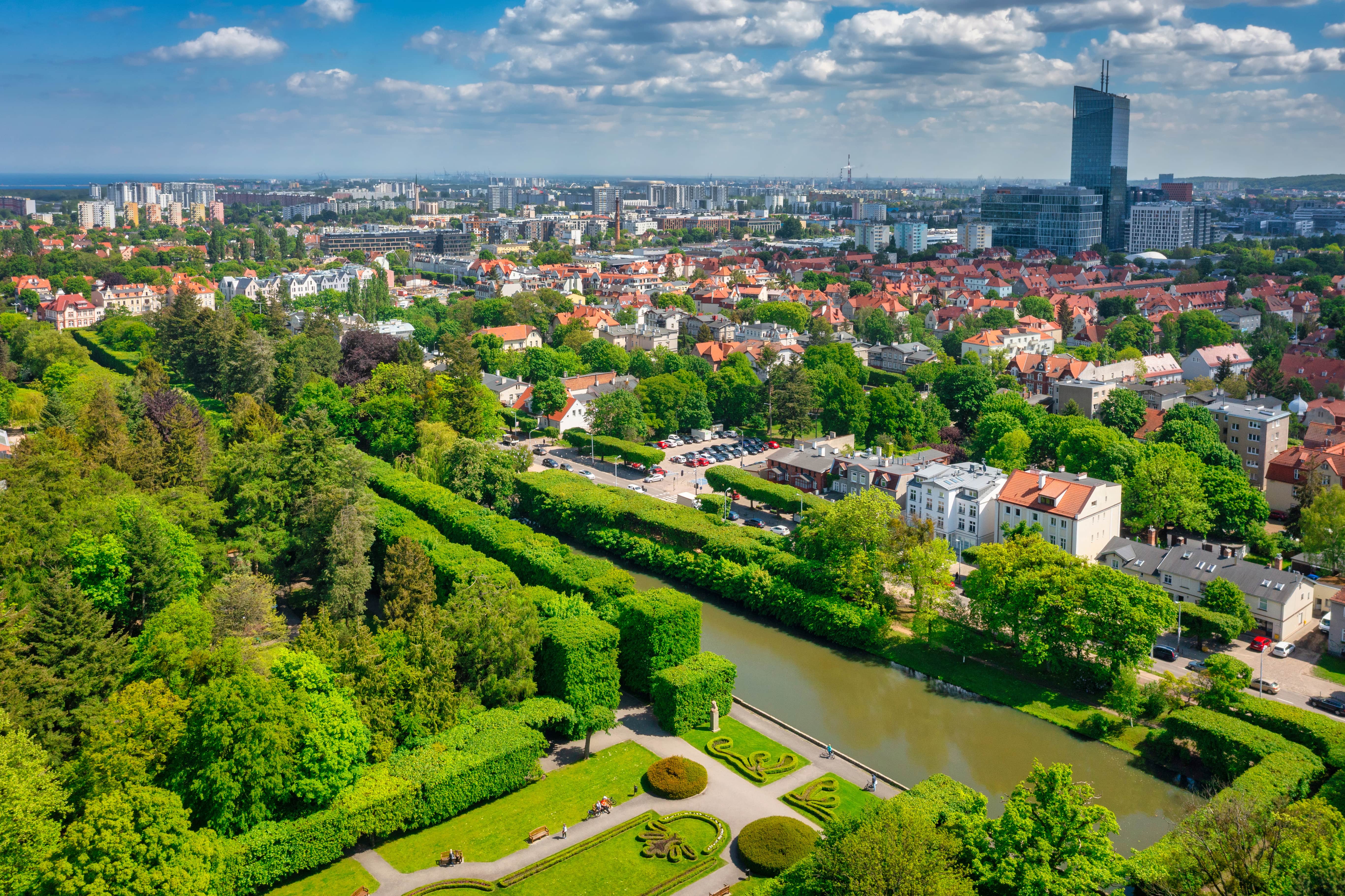 Resa tii Polen - Panoramavy över grönskande skog som möter en stad och byggnader i Polen