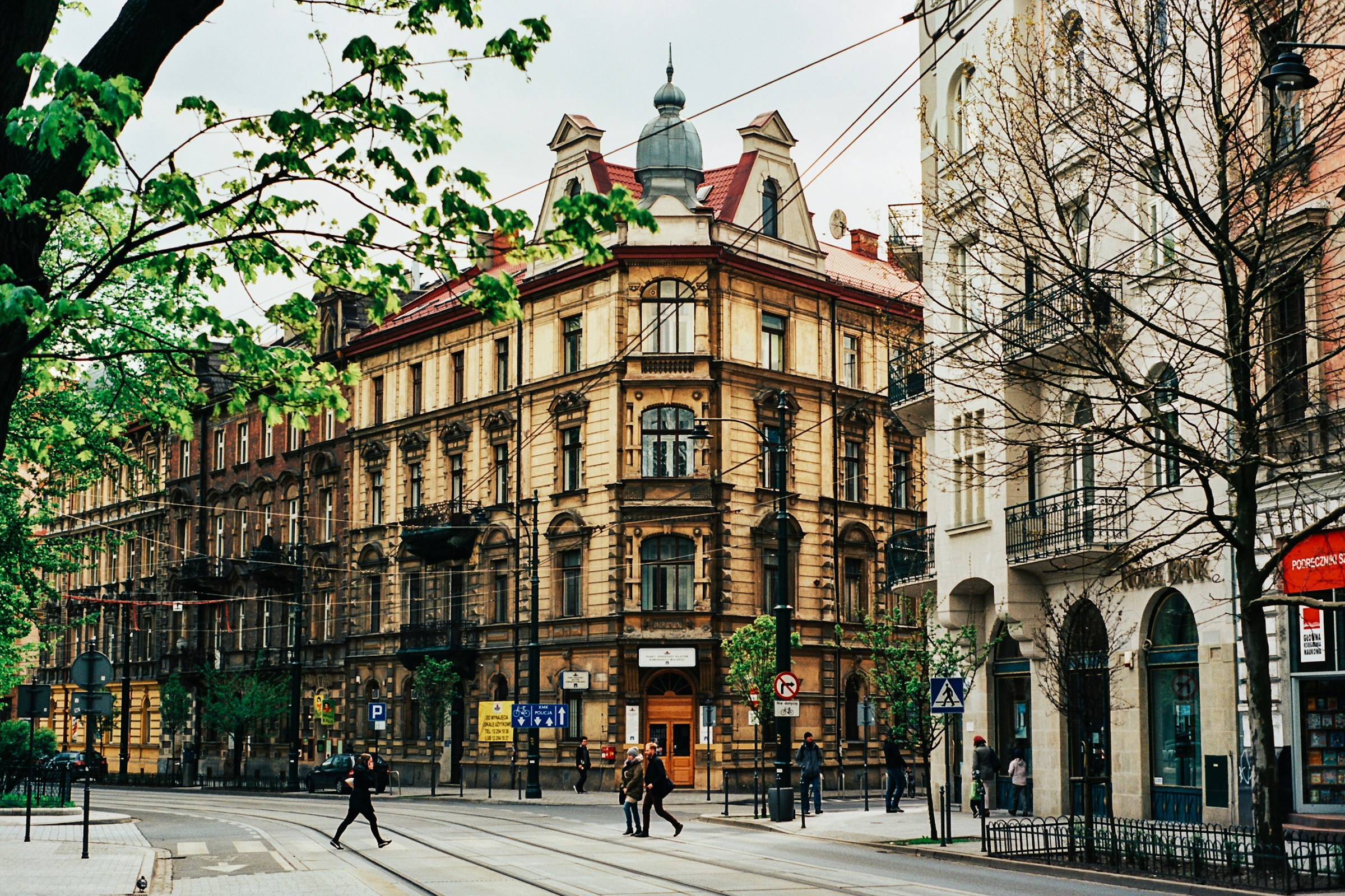 En korsning vid en äldre vacker byggnad i centrala Krakow i Polen