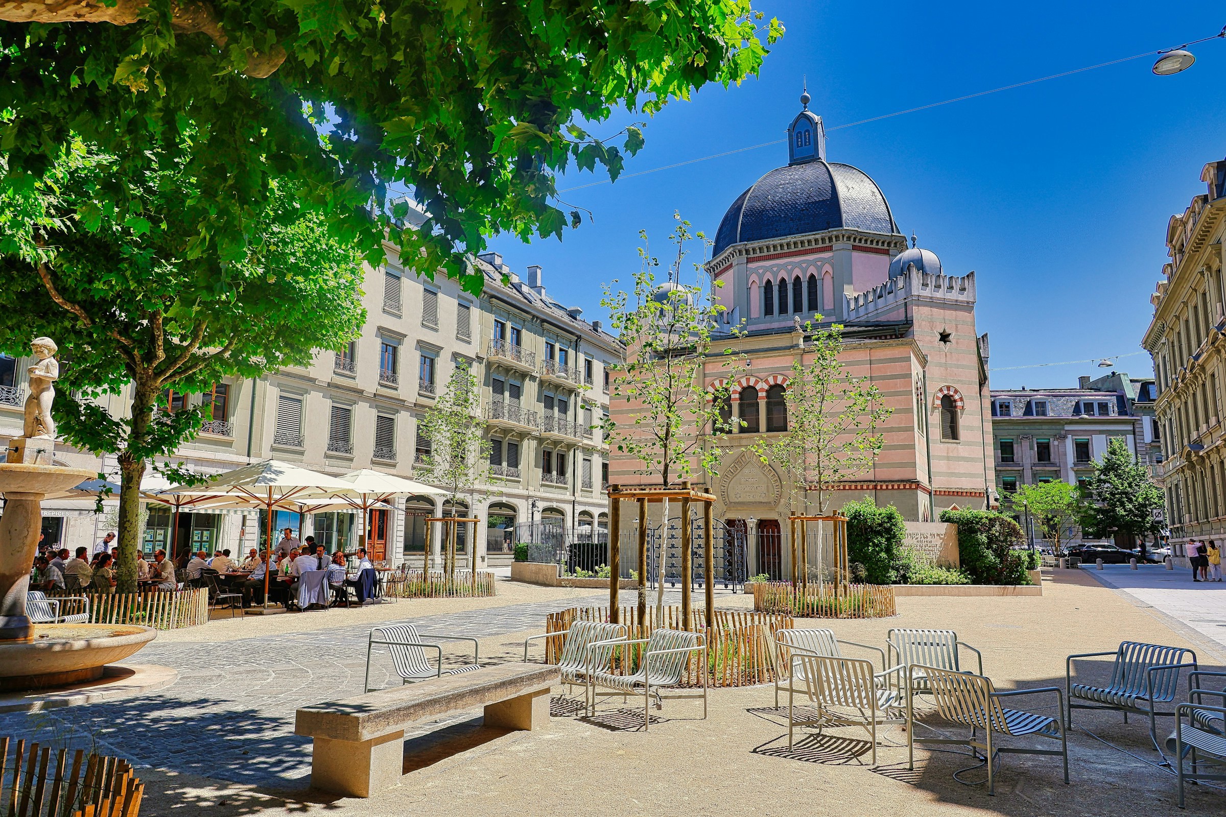 A square with outdoor seating and beautiful buildings in the center of Geneva, Switzerland