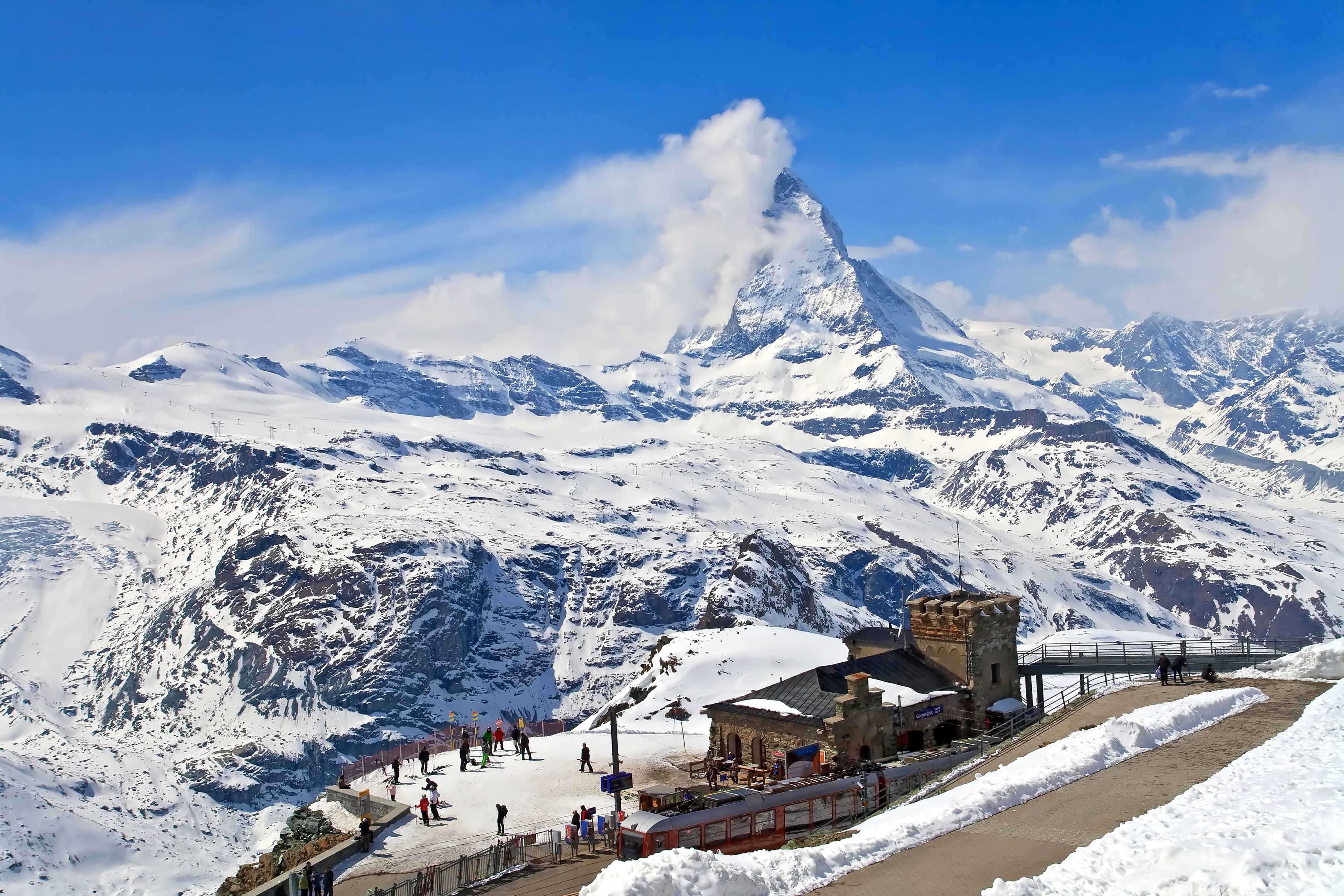 Resa till Zermatt - Vy av Matterhorn med skidåkare och besökare vid Gornergrat observatoriet i de schweiziska Alperna under vintern.