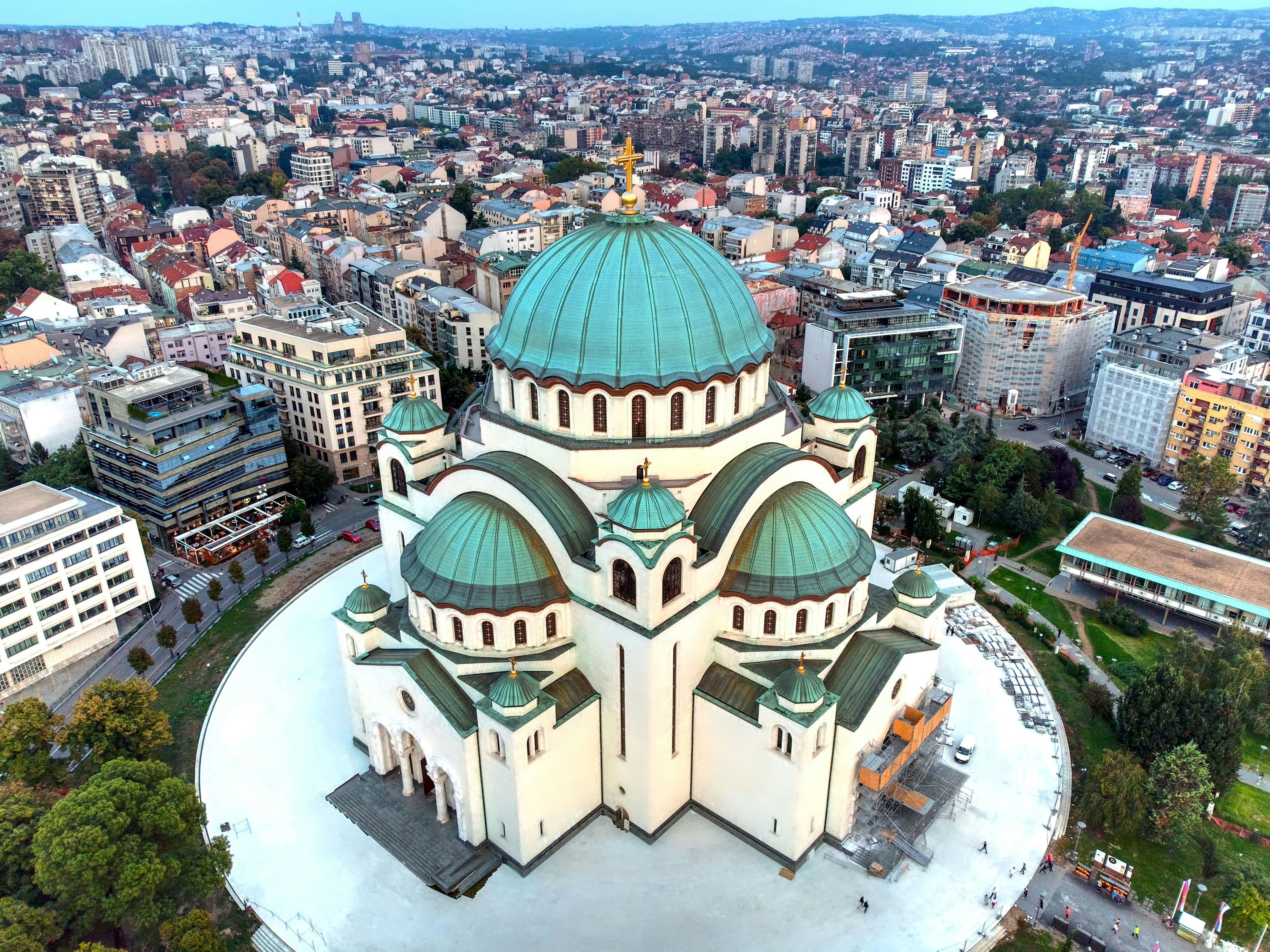 Vacker kyrka med blå kupoltak i centrala Belgrad i Serbien med byggnader runtomkring