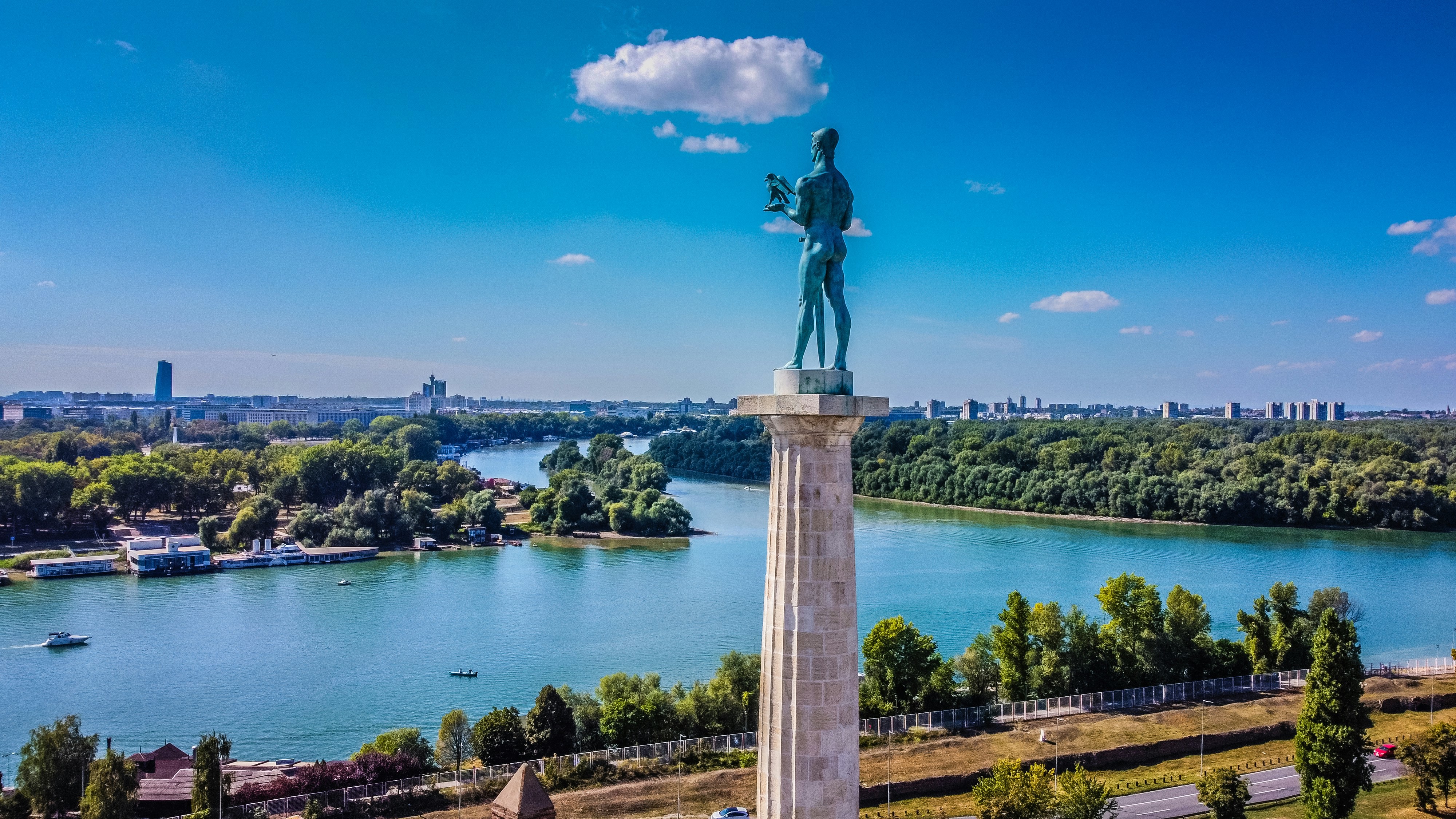 Staty som står över en stad i Serbien med en sjö som kommer in mellan ögrupper