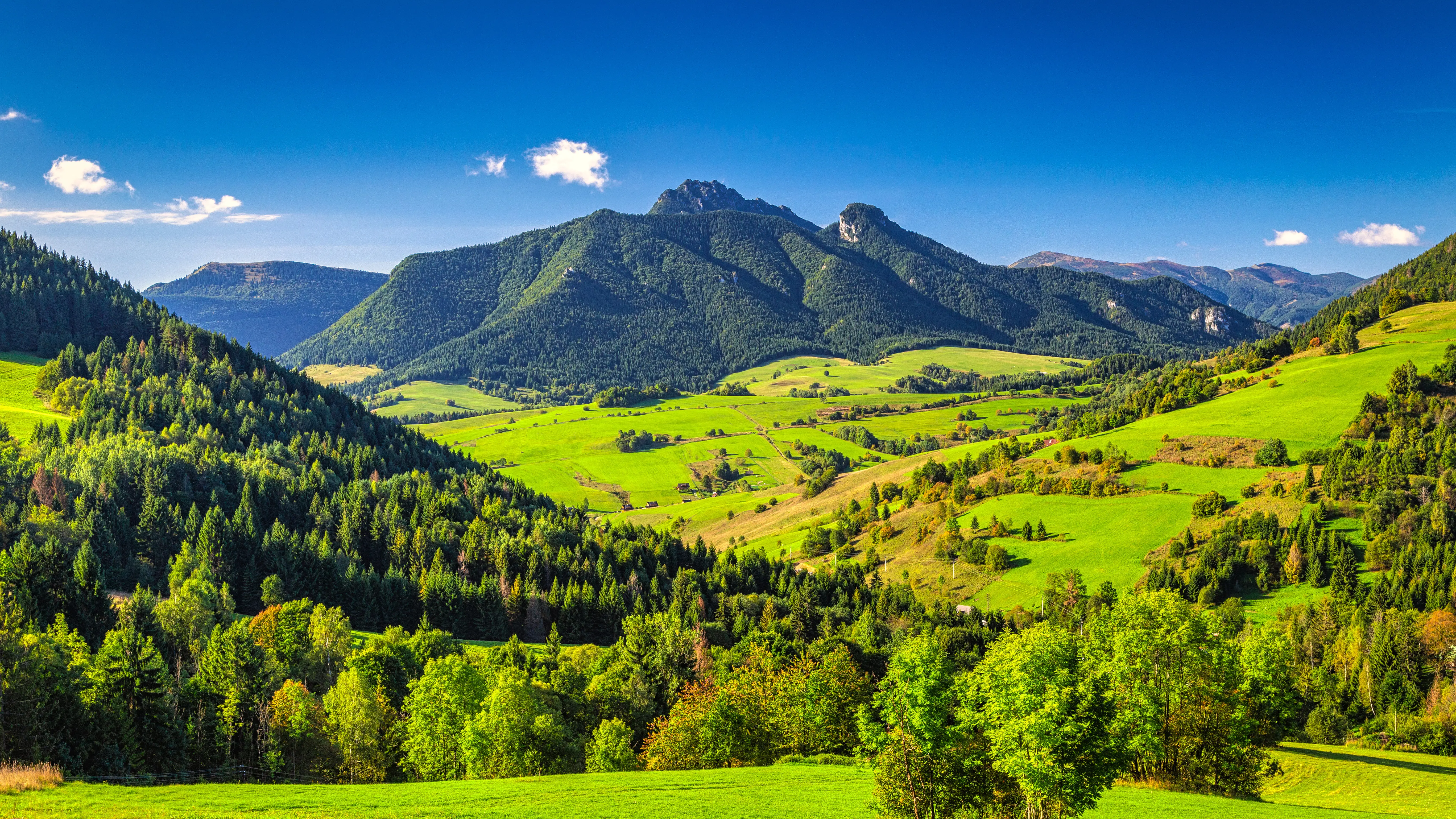 Resa till Slovakien - Bergslandskap med gröna ängar under klarblå himmel i Slovakien-