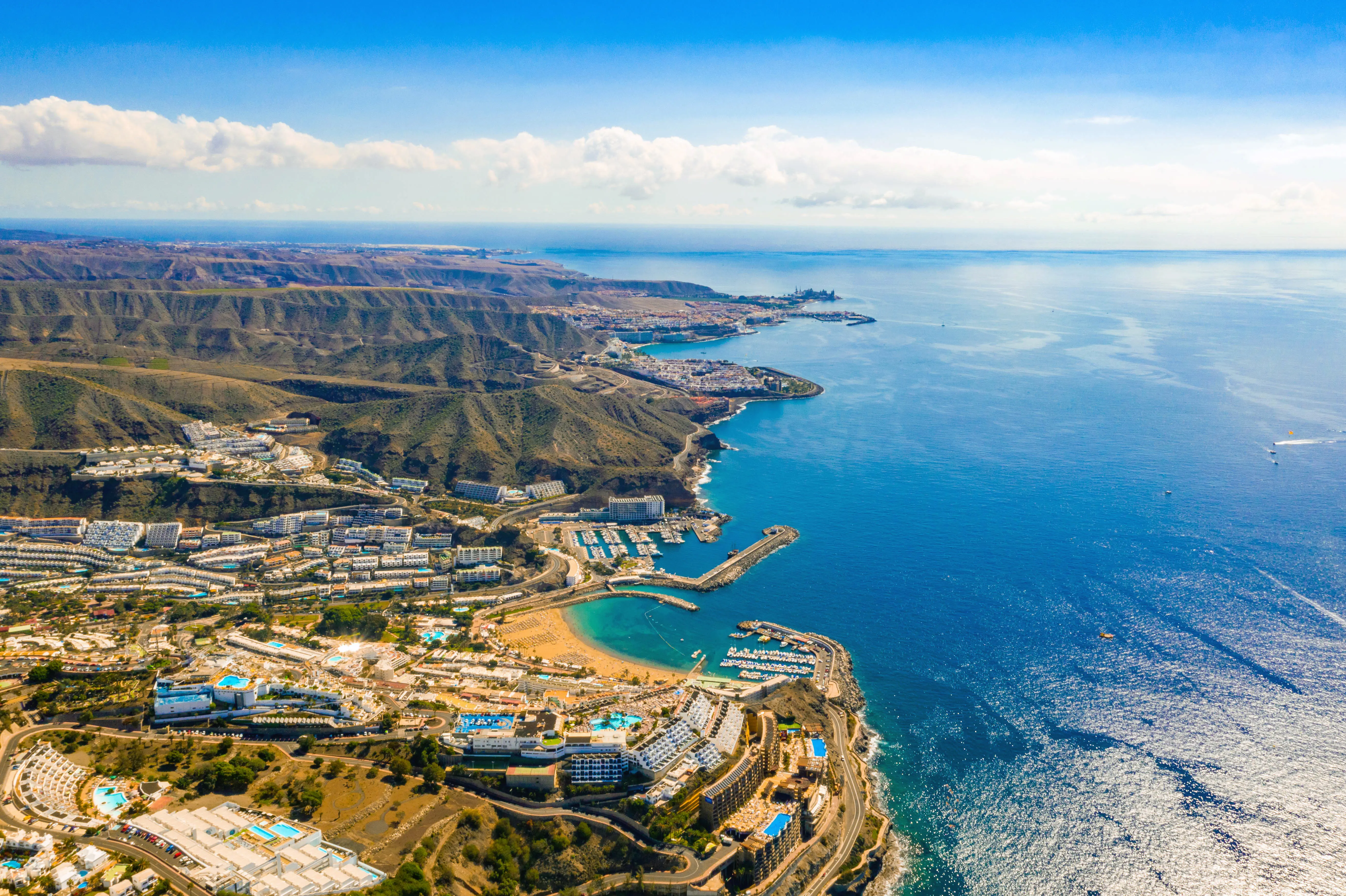 Resa till Gran Canaria - Flygbild över kuststad med blått hav, stränder och marina.