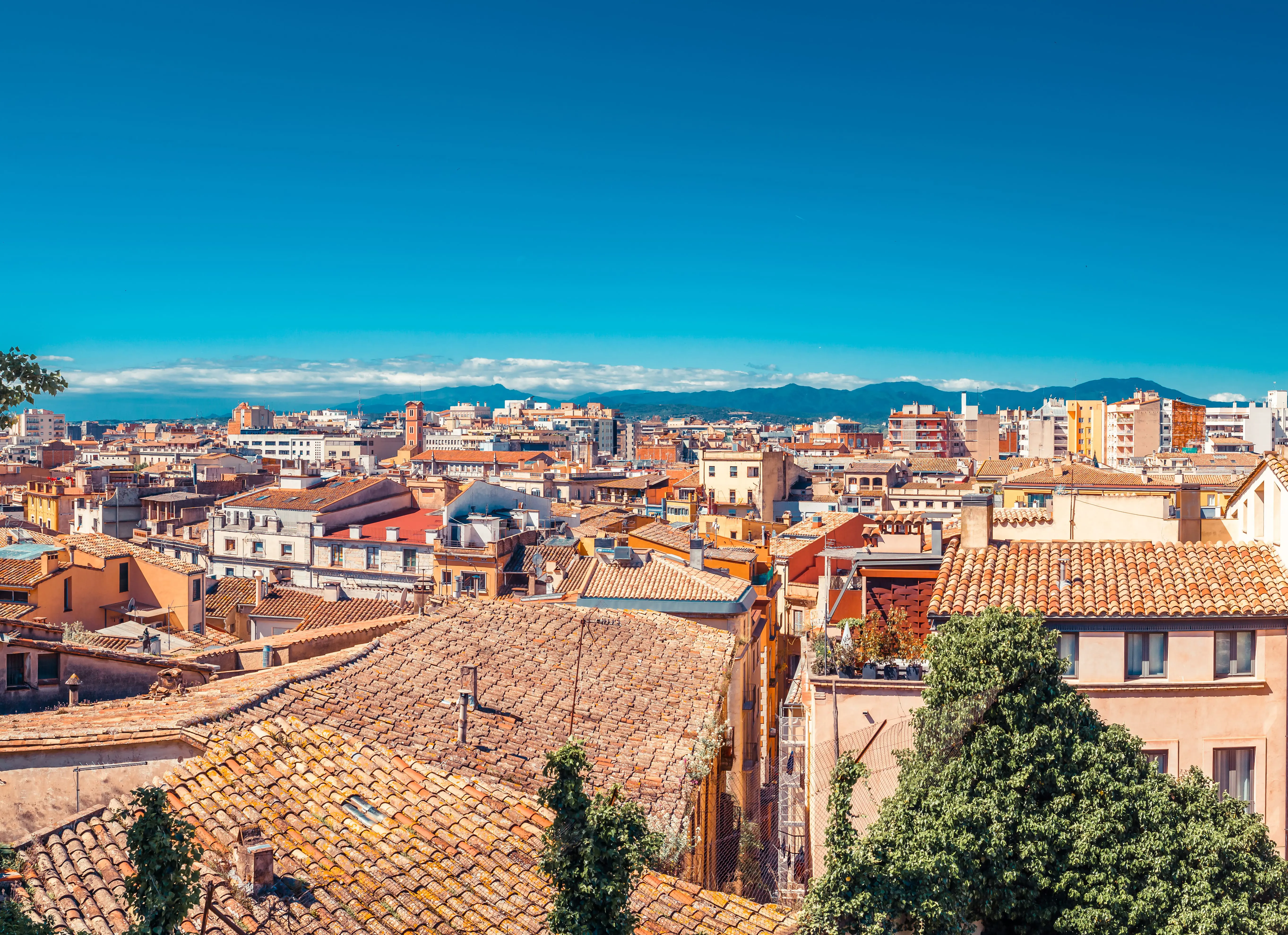 Bruna vackra hustak över en stad i Spanien med klarblå himmel i bakgrunden