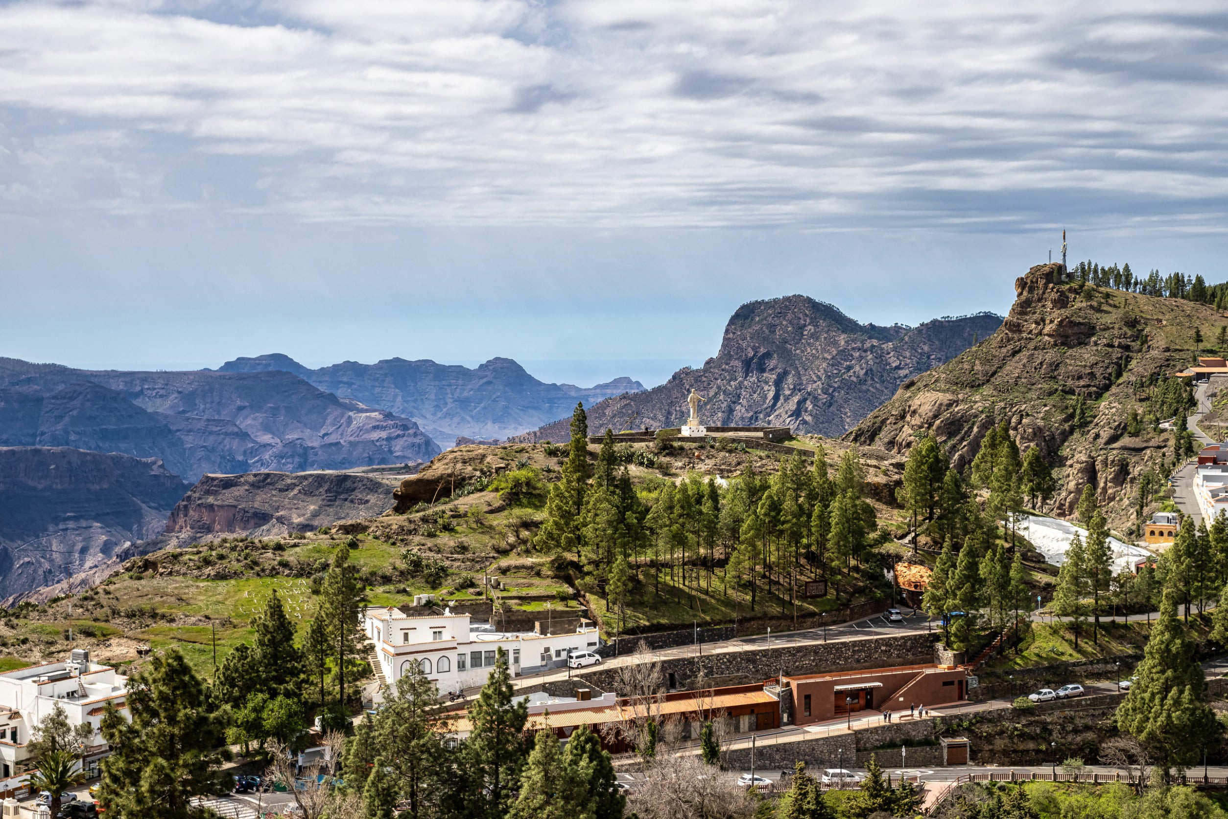 Byggnader bland grönskande djungel med utsikt över berg på Gran Canaria