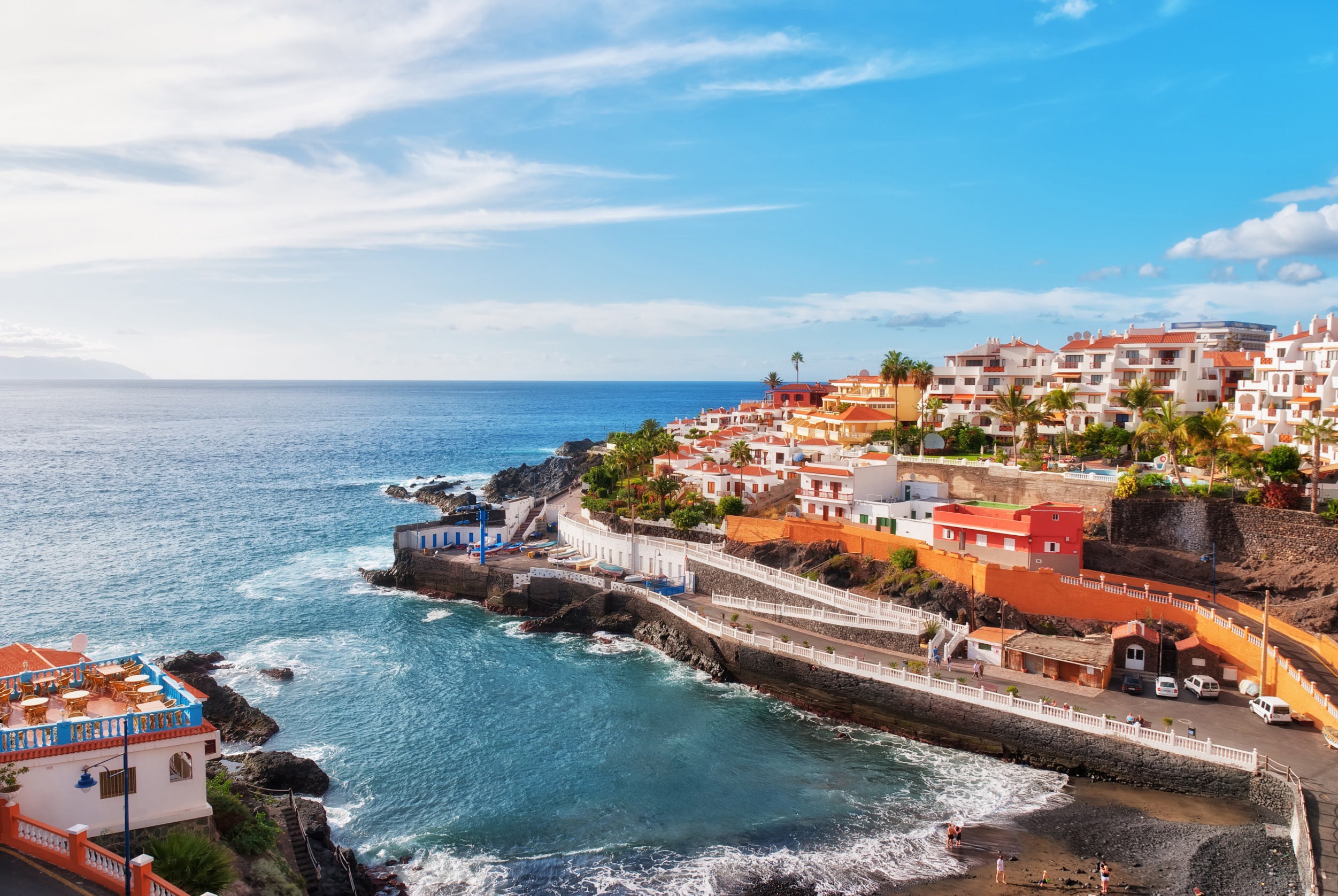 Stor och tom strand längs blått hav vid katen av Lanzarote med blå himmel i bakgrunden