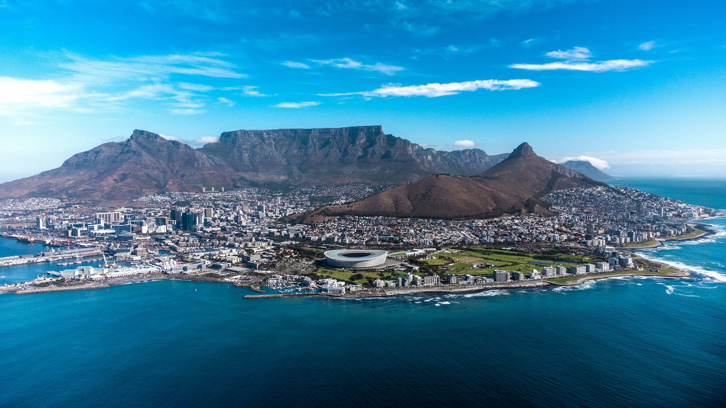 Fågelvy över kustkanten av Kapstaden i Sydafrika med stora berg i bakgrunden