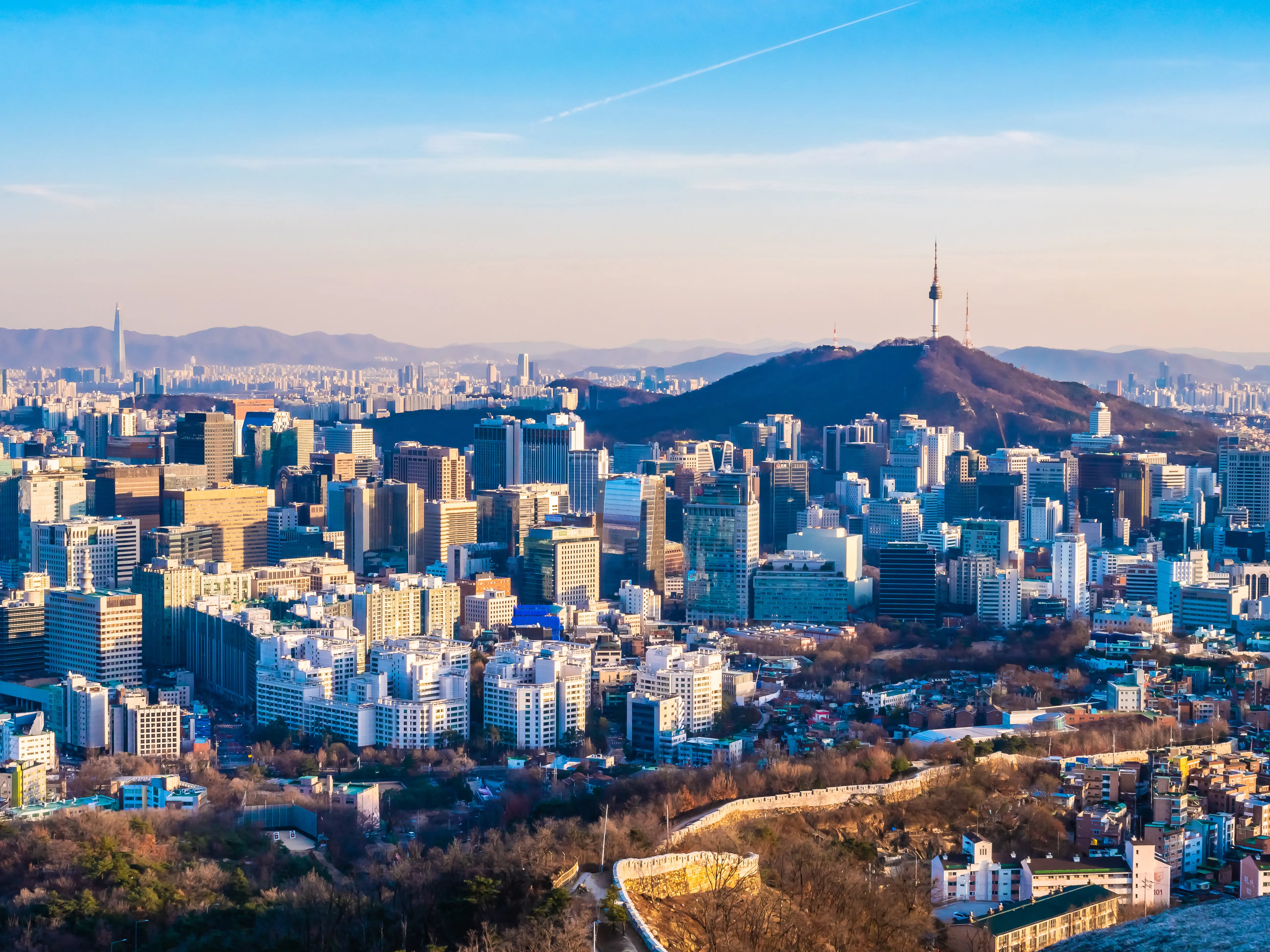 Resa till Seoul - Flygfoto över Seouls stadssiluett med Namsan Tower i klarblå himmel vid solnedgång.