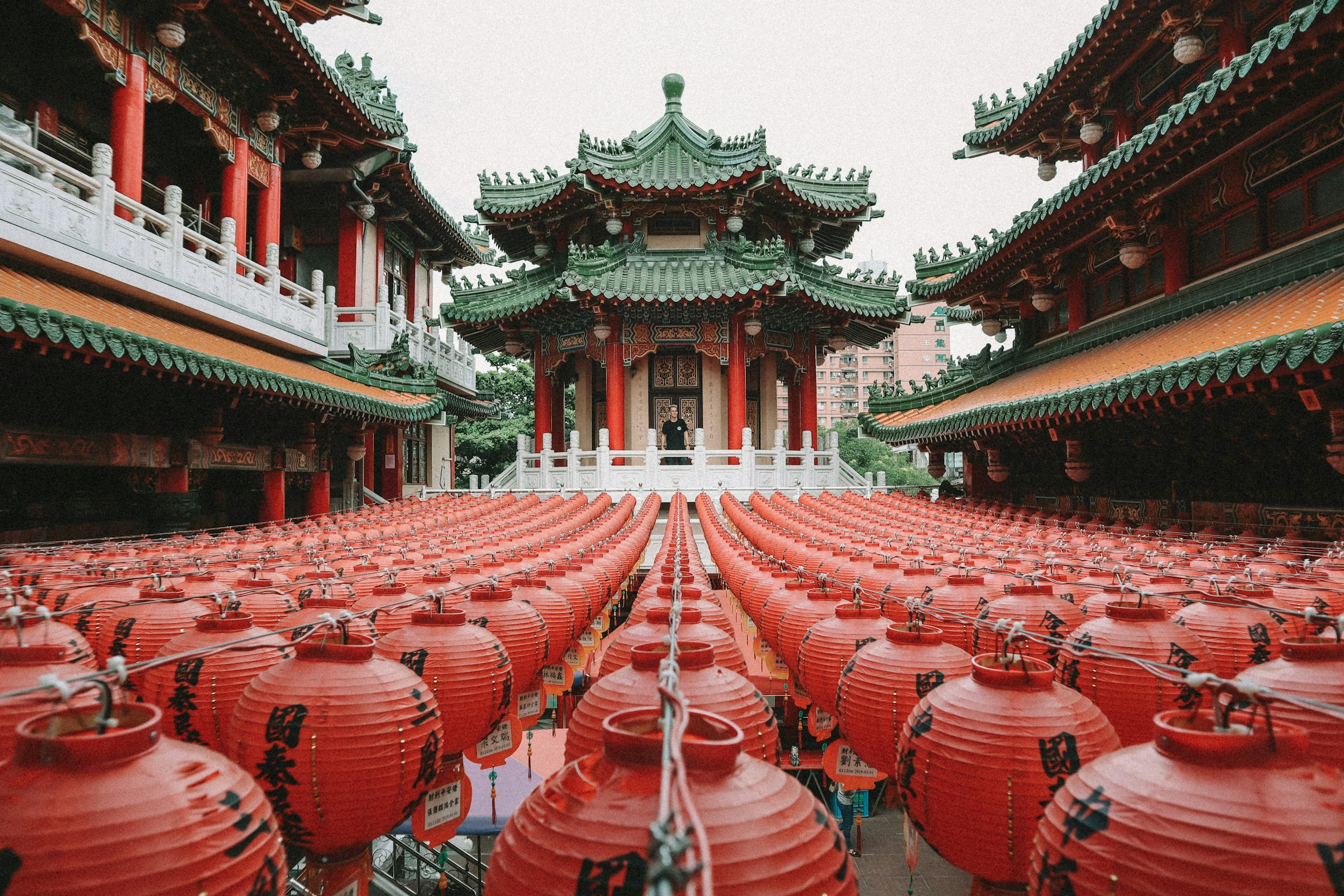 Ett röd tempel med grönt tak och klassiska runda röda lyktor omkring sig i Taiwan