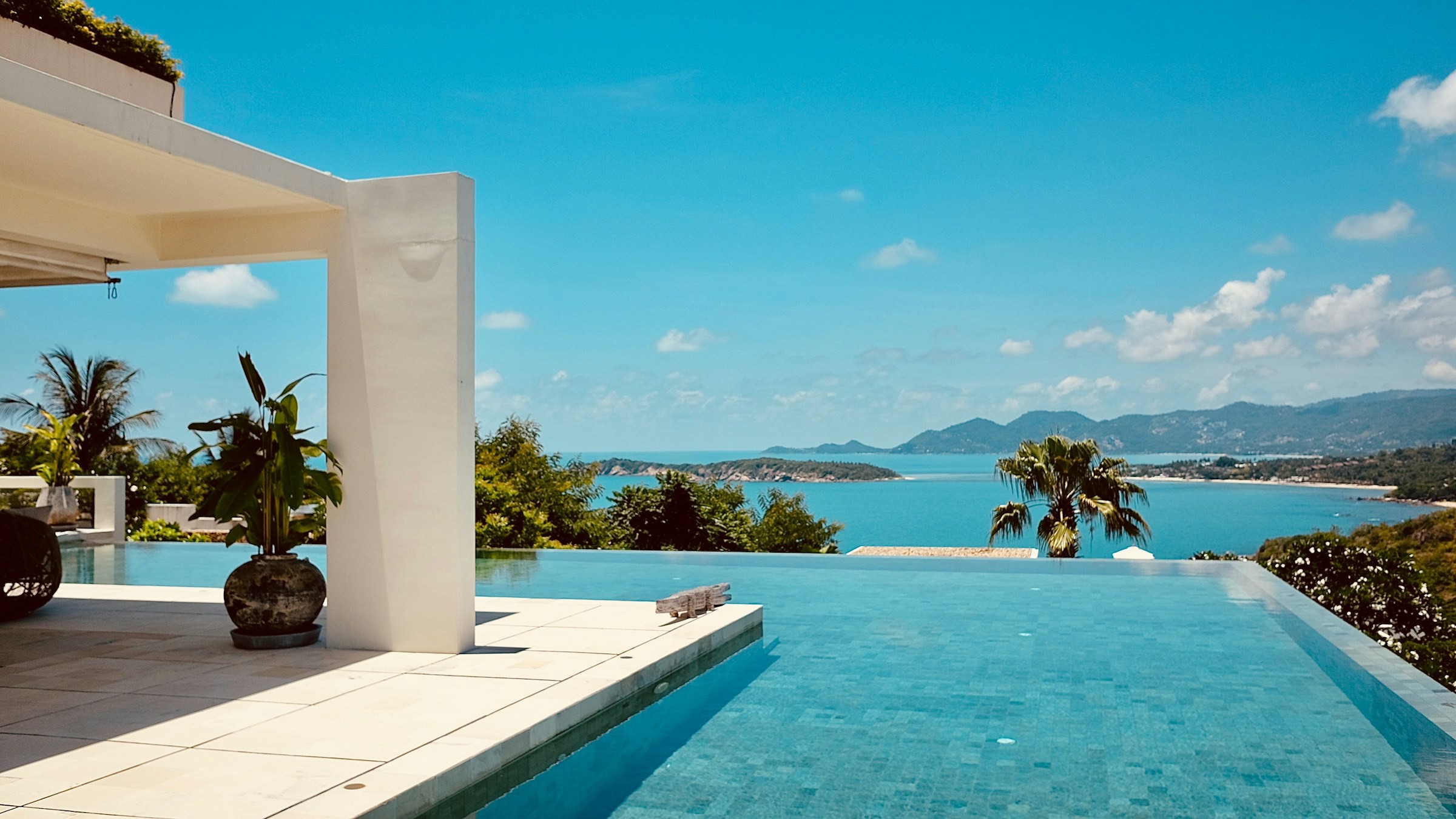 Vy från en pool på ett vackert resort på Koh Samui, Thailand med utsikt över havet och djungeln