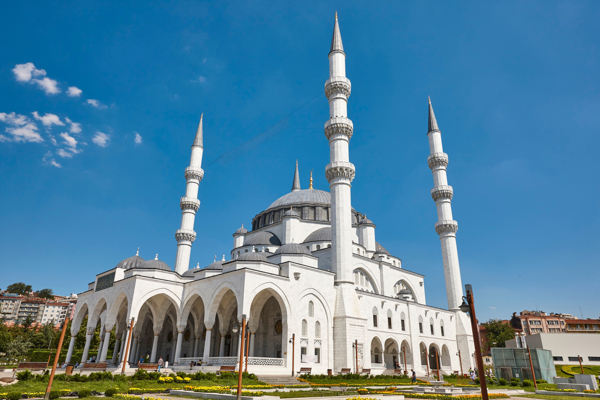 Vacker vit moské i Ankara med grönt gräs runt sig mot en blå himmel i bakgrunden