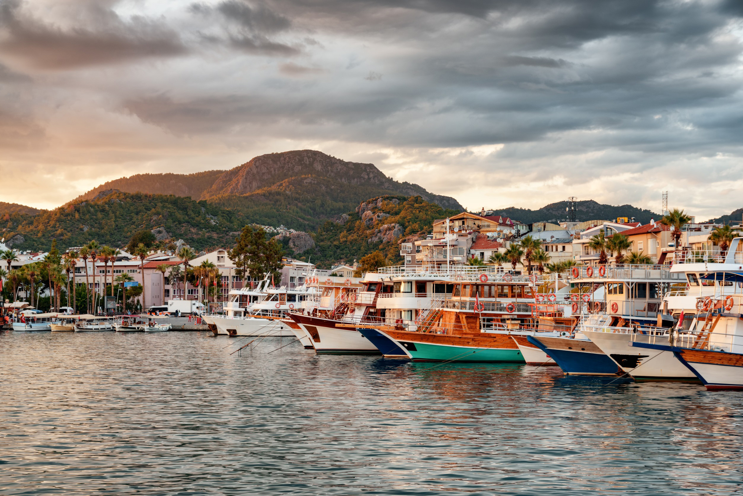 Sunset at a port in Marmaris filled with boats and beautiful mountains in the background