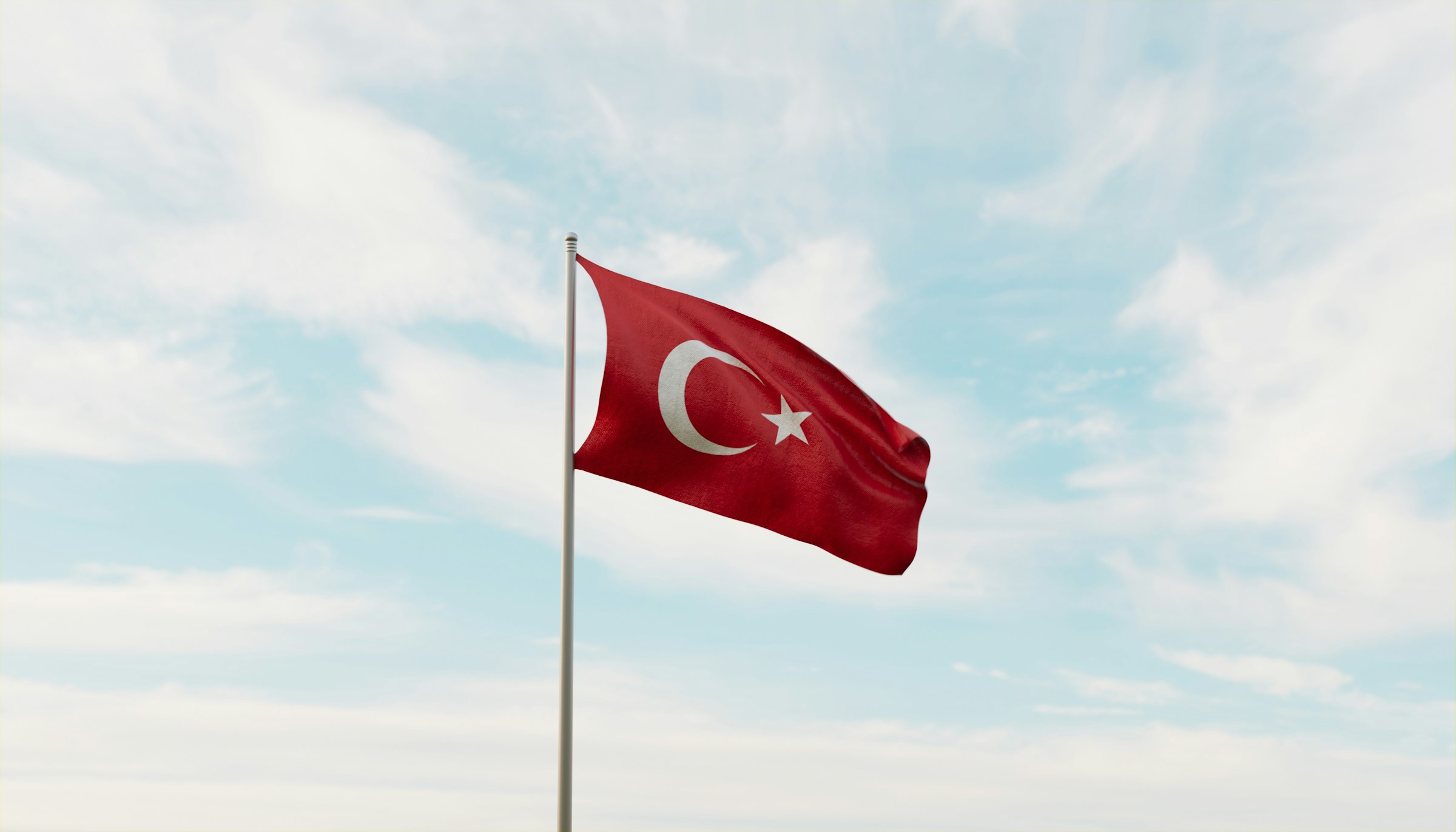 Turkiets flagga viftar på en flaggstång mot en molnig himmel