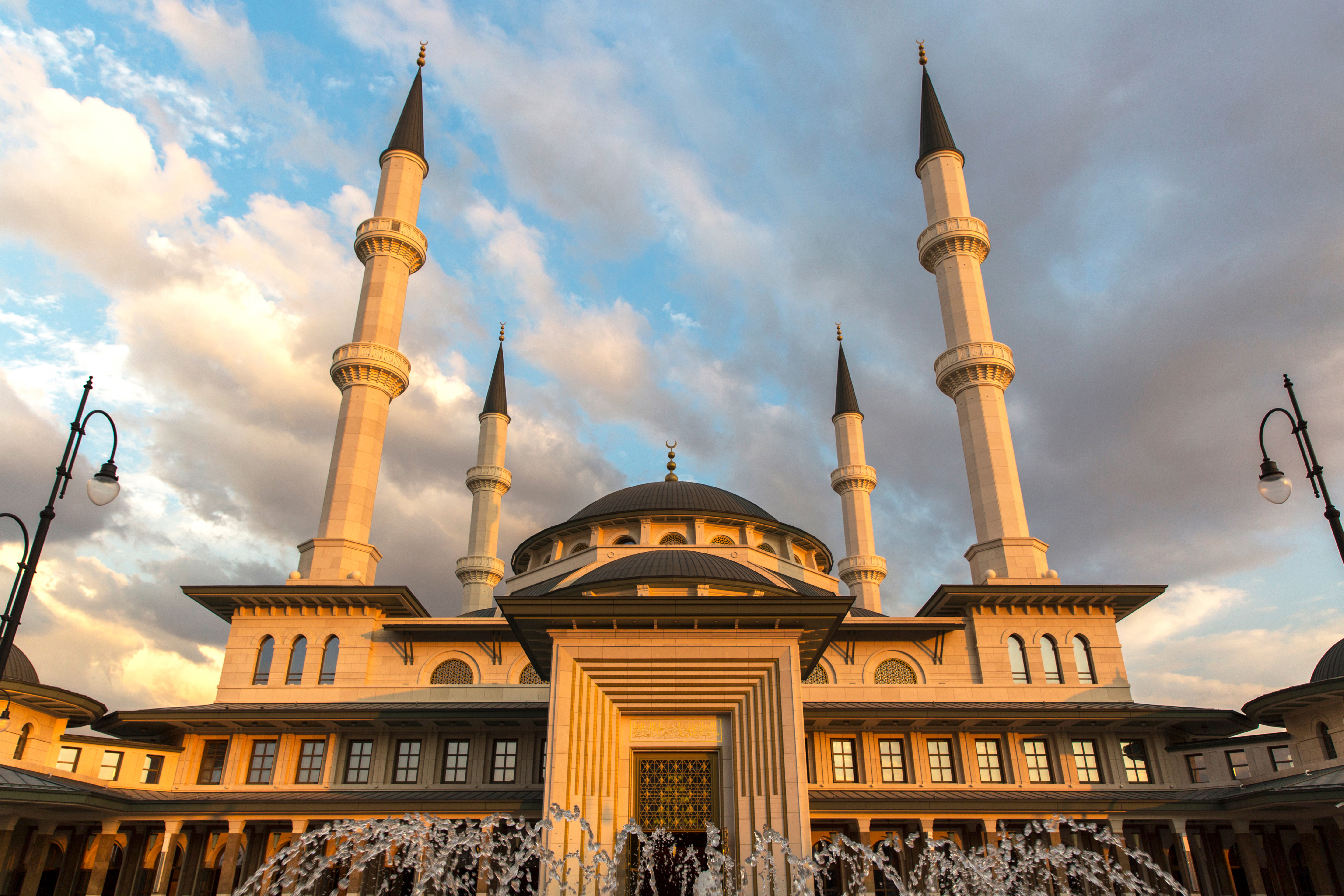 Vy underifrån på en moské i Ankara som står upp med sina torn upp mot en himmel under skymning