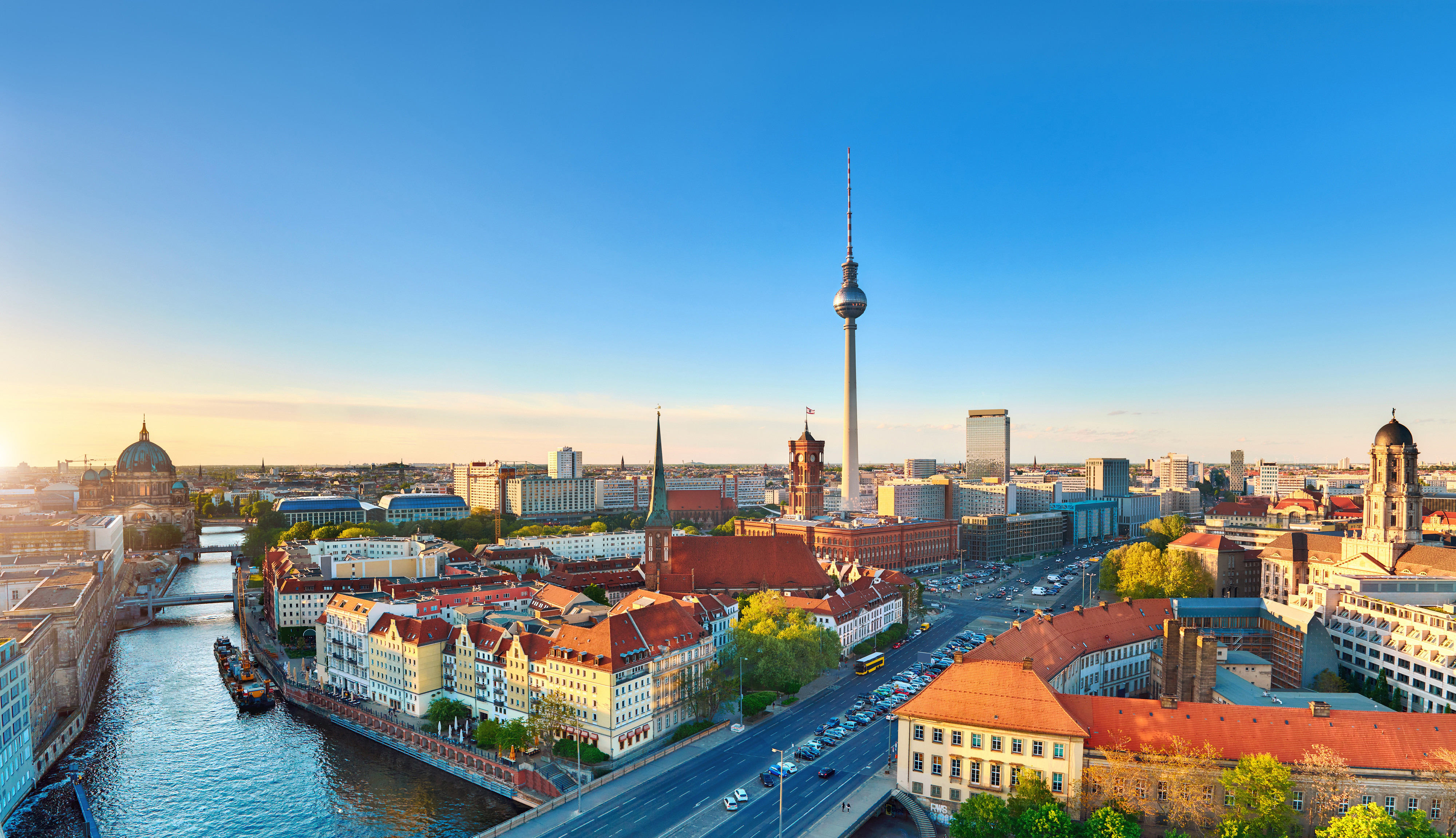 Resa till Berlin - Panoramautsikt över Berlin stadssilhuett med TV-tornet och Spreefloden vid solnedgången.