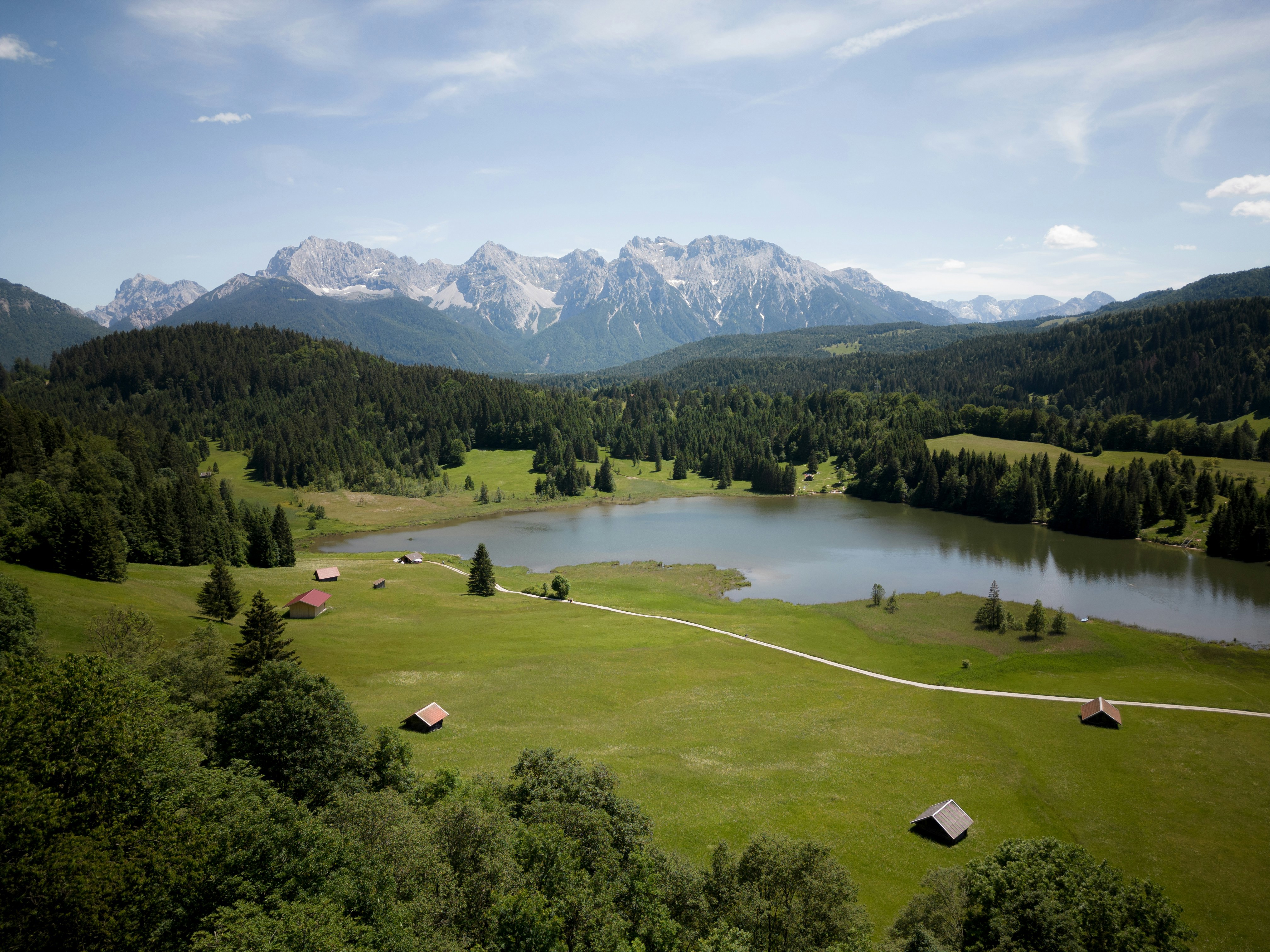 Vackert naturlandskap i panoramavy över gröna ängar, skog, sjö och berg i bakgrunden i Tyskland