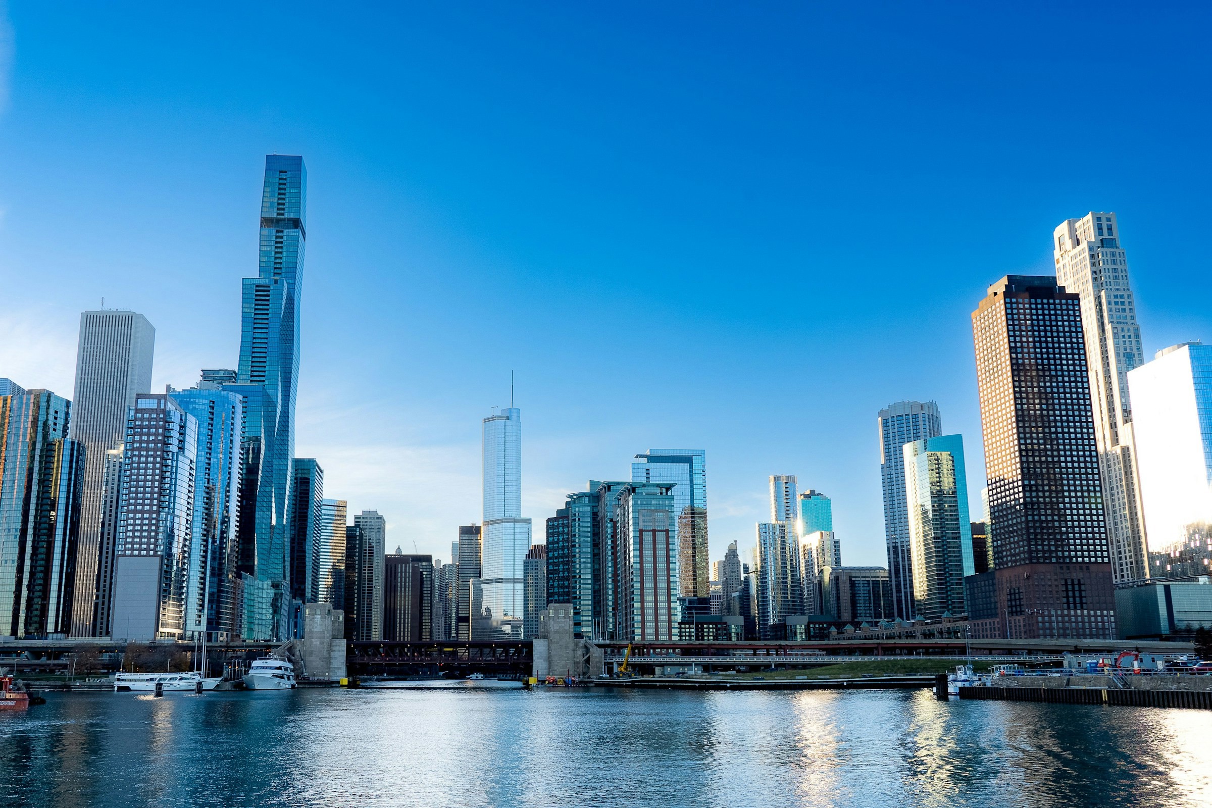 Vy över downtown Chicago från vattnet upp mot imponerande skyskrapor som går upp mot en blå himmel