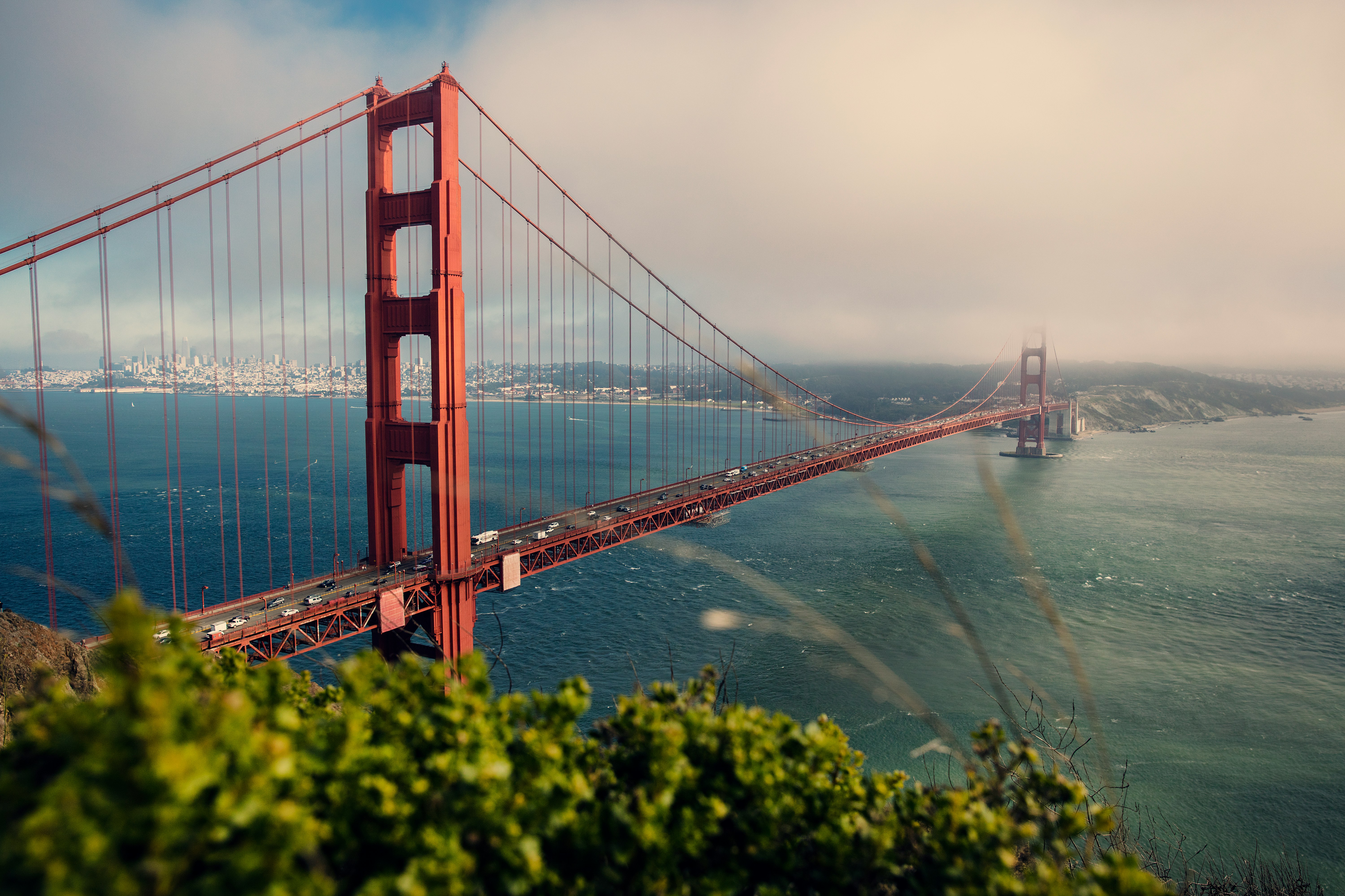 Resa till San Francisco - Vy över klassiska röda Golden Gate Bridge över vatten in i dimma på andra sidan