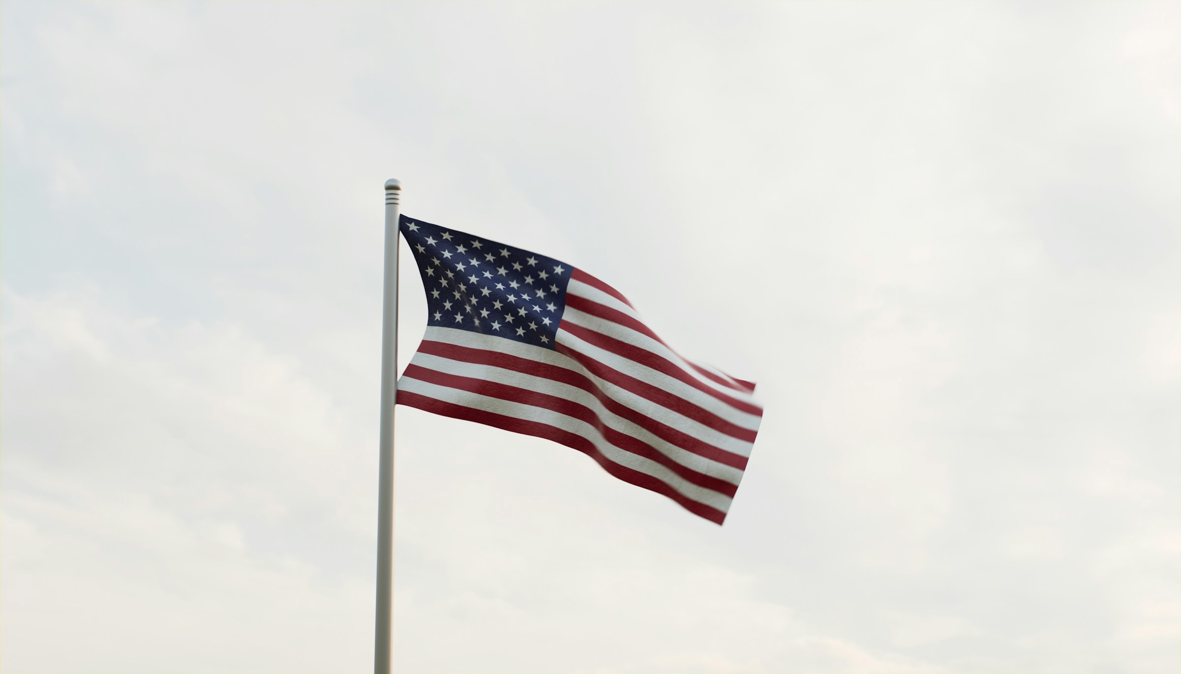 Amerikanska flaggan viftar i en flaggstång mot en grå himmel