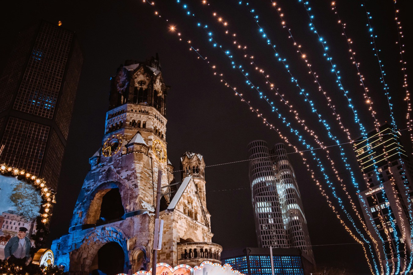 Julkväll med upplysta ljusslingor och Kaiser-Wilhelm-Gedächtniskirche i bakgrunden i Berlin, Tyskland.